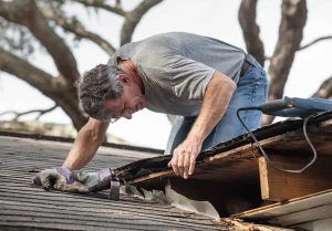 Roofing contractor inspecting roof damage before estimating repair costs.